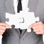 Businessman Holding Mismatch Jigsaw